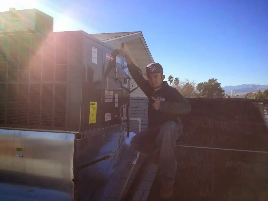HVAC technician performing AC Tune-Up on a rooftop unit in Highlands